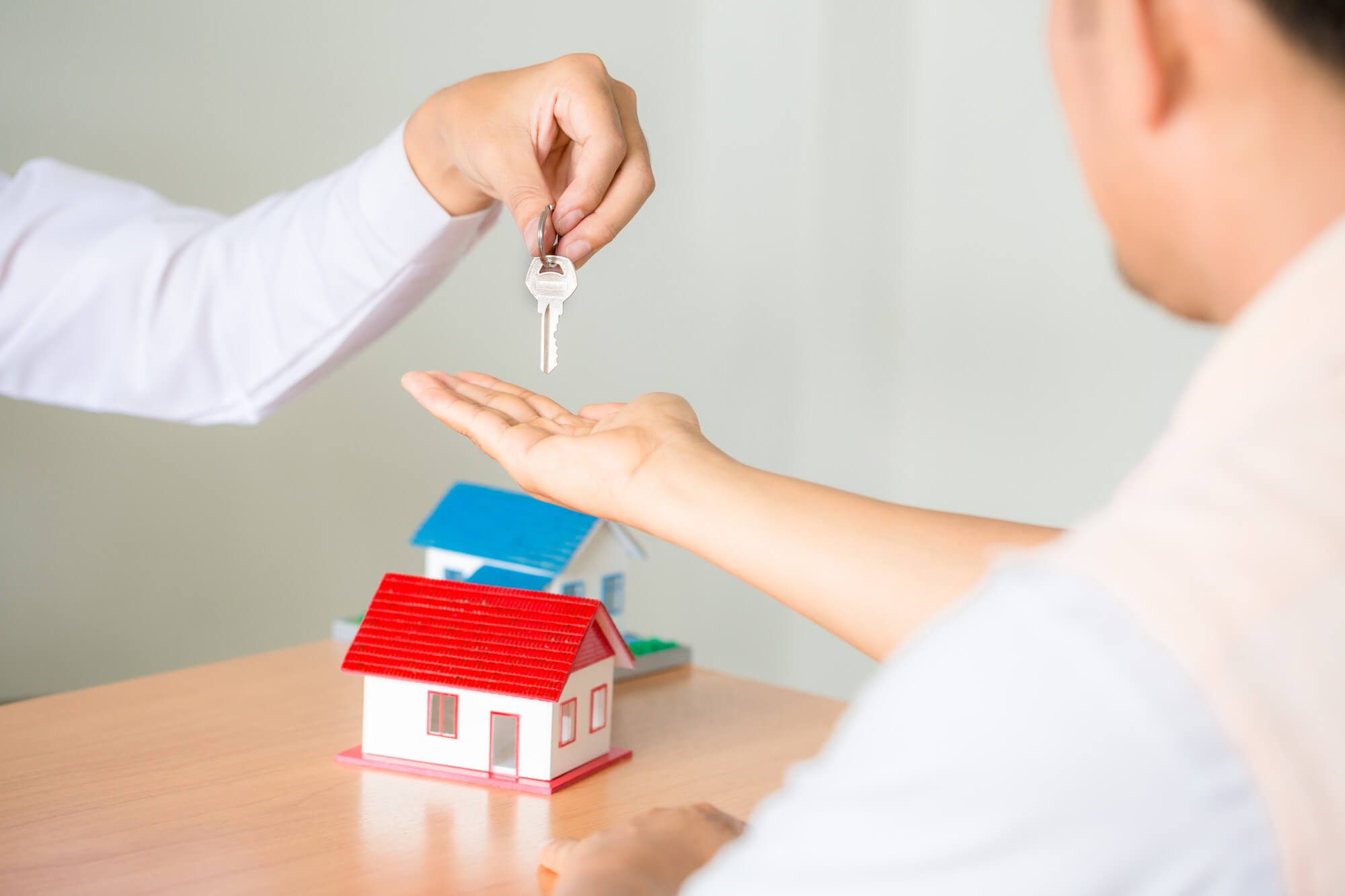 One individual giving house keys to another one