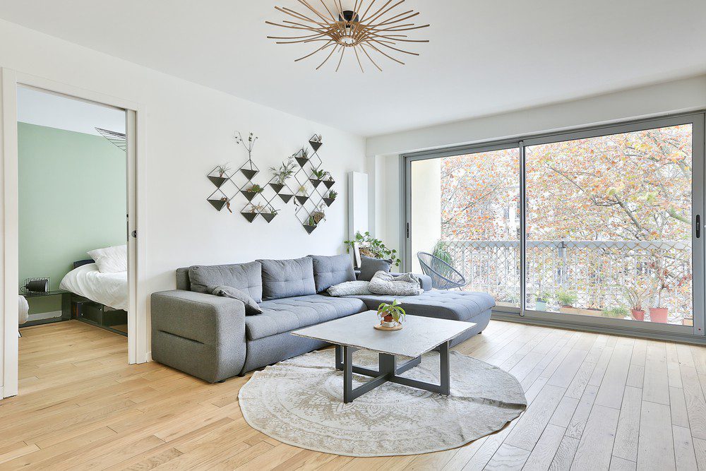 Living room with a sofa and a garden view in a Paris apartment