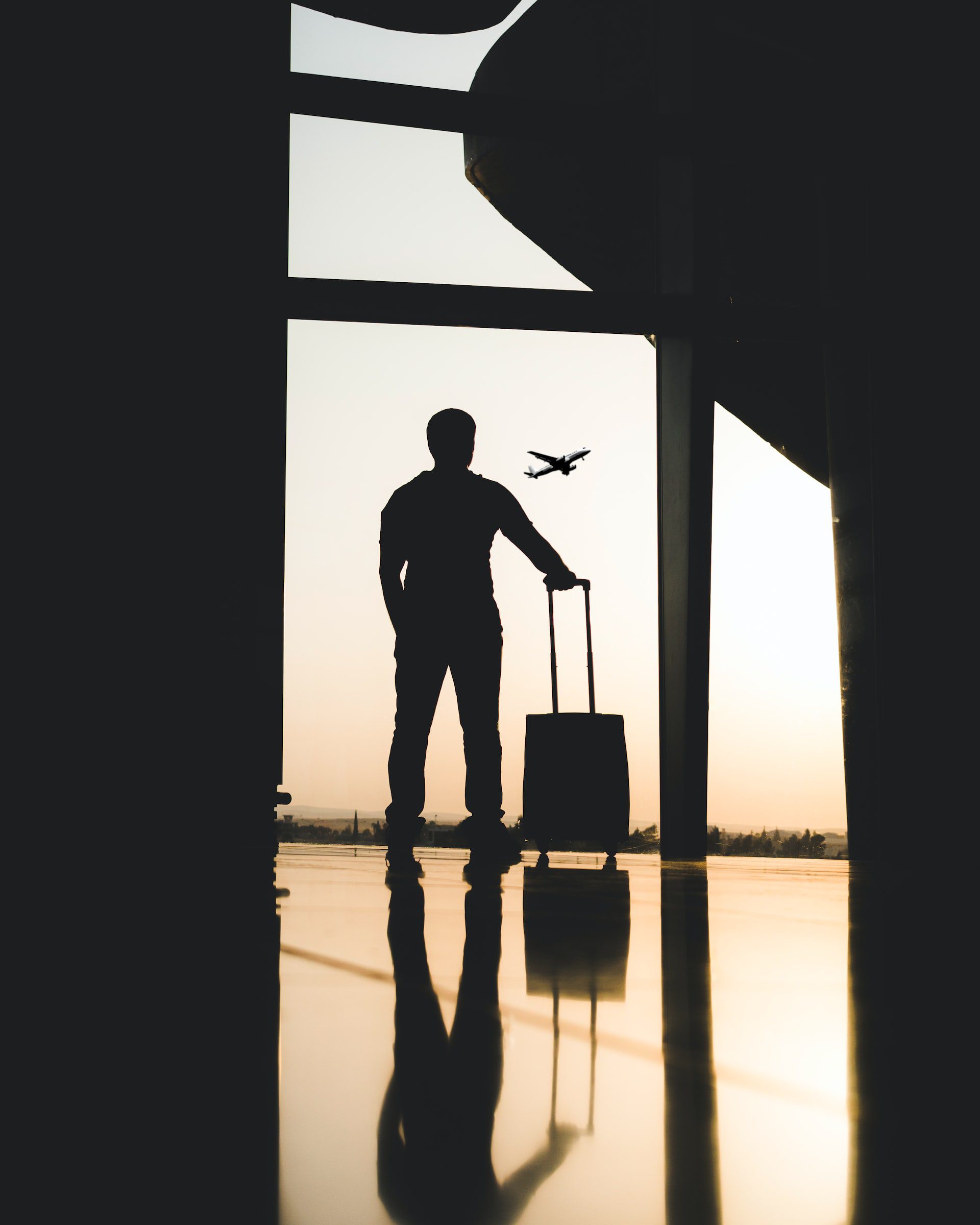 Man with suitcase in the airport - Image by Yousef Alfuhigi