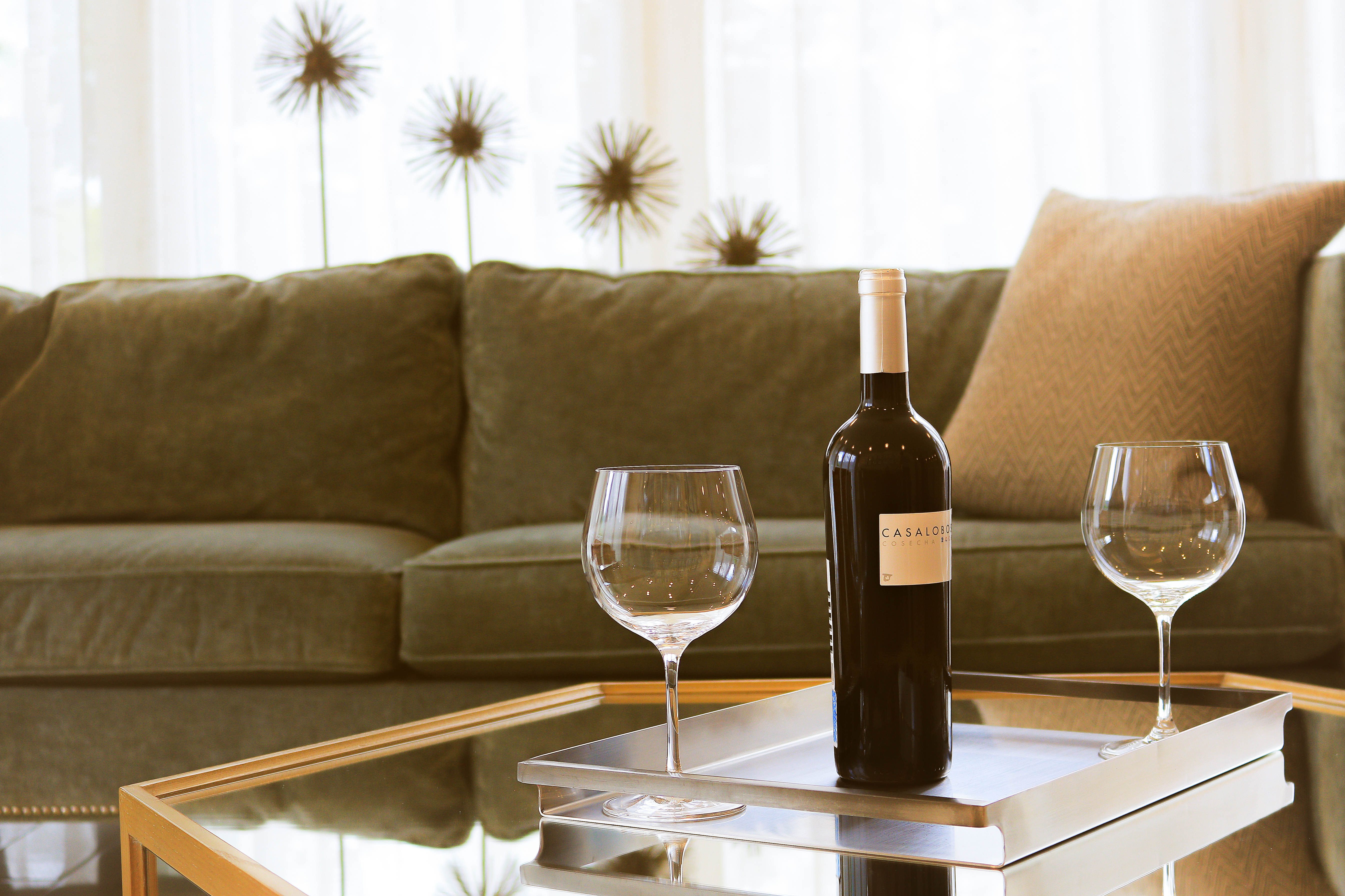 wine bottle and two glasses on top of a coffee table in an airbnb apartement managed by guestready