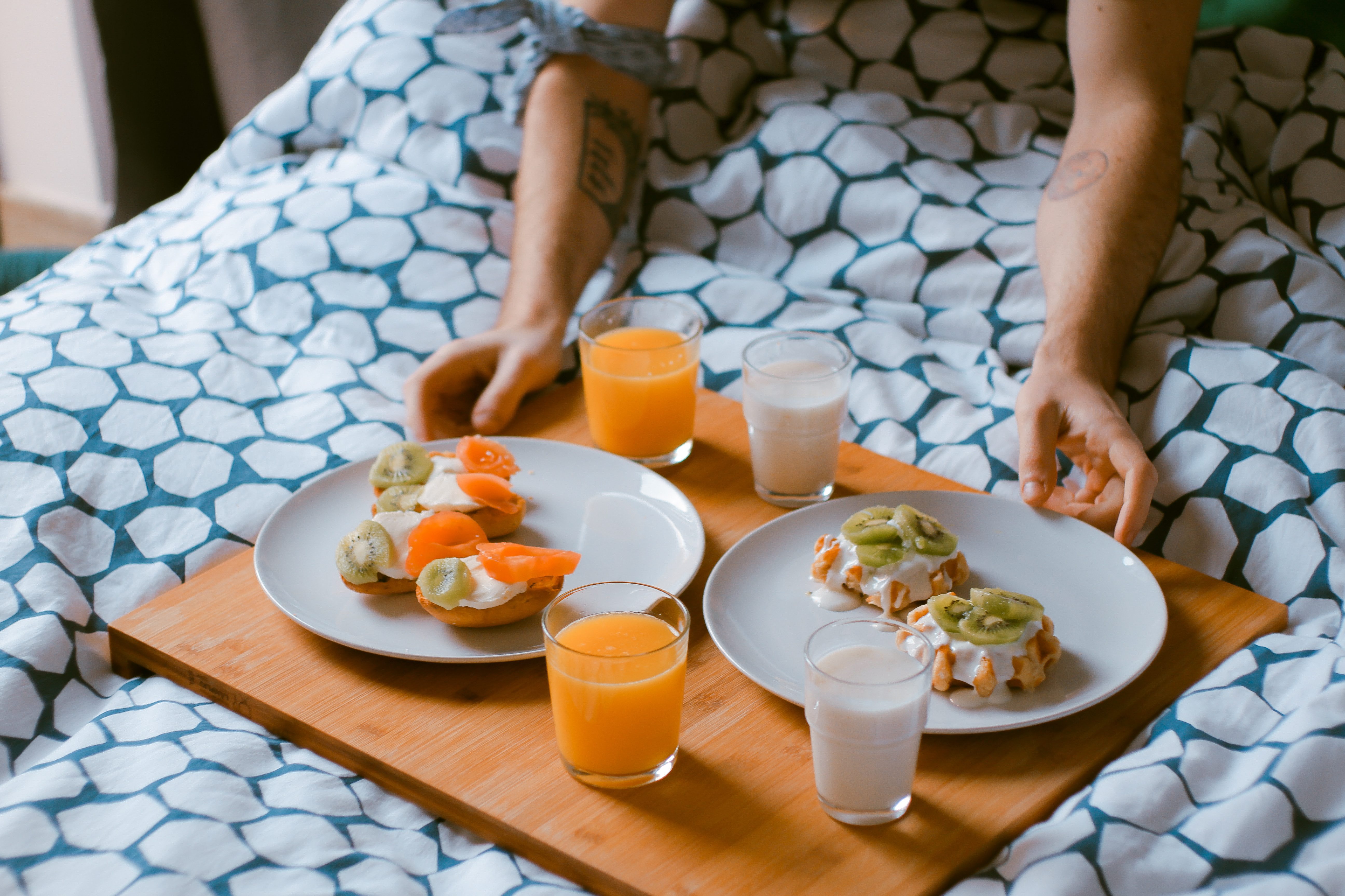 Hóspede a tomar o pequeno-almoço na cama num apartamento de alojamento local em Portugal com todo o conforto de uma segunda casa